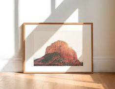 a framed photograph sitting on top of a hard wood floor next to a white wall