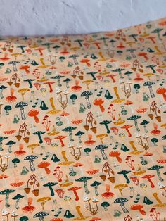 an orange and green fabric with mushrooms on it