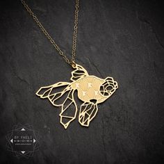 This unique gold fish necklace is a stunning piece of handmade jewelry, perfect for nature lovers. The geometric goldfish pendant is crafted with precision and care, offering a blend of elegance and whimsy. The delicate gold chain adds a touch of sophistication, making it an ideal gift for her on any occasion. ★ Comes in our signature gift box, ready for gift giving.  ★ Available in Gold [ gold-filled chain & gold plated brass pendant]  ★ Pendant size is 1.4"x 1.7" .  Thanks for shopping at ByYa Gold Fish-shaped Necklace For Gift, Gold Fish Necklace, Geometric Fish, Pisces Jewelry, Pisces Necklace, Origami Necklace, Fish Jewelry, Fish Necklace, Gold Fish