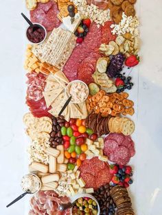 an assortment of cheeses, crackers, and meats on a platter