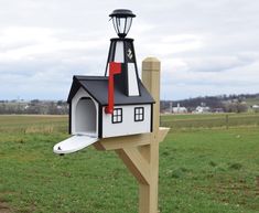 a house shaped mailbox with a surfboard sticking out of it's roof