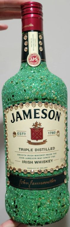 a bottle of jameson sitting on top of a counter next to a person's hand