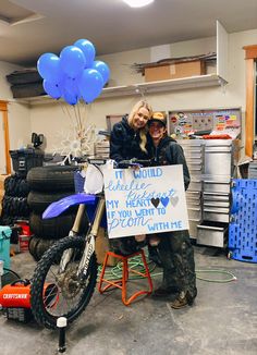 two people sitting on a motorcycle holding a sign with balloons attached to it and the words i would love my heart if you went to ride