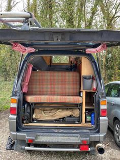 the back end of a van with its doors open and seats folded up in front