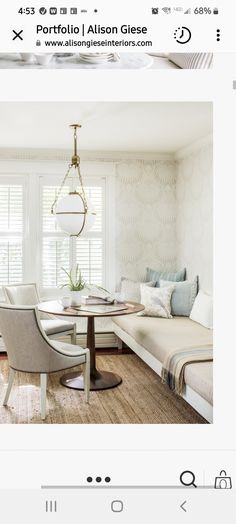 an image of a living room with white walls and wood flooring, including a round table