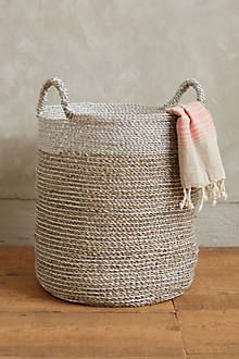 a large woven basket sitting on top of a wooden floor