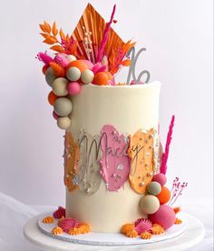 a white cake with orange and pink decorations on it's side, sitting on top of a table