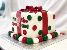 a cake decorated with red, white and green polka dots on a silver platter