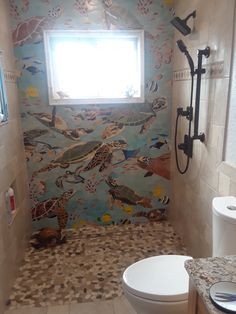 a bathroom with a toilet, sink and window in the shower stall that has birds on it