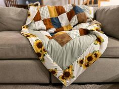 a couch covered in a blanket with sunflowers on it