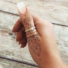 a woman's hand with a henna tattoo on her left arm and wrist