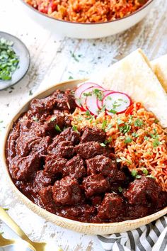 a bowl filled with meat and rice next to a plate full of food on a table