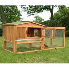 a wooden chicken coop in the grass