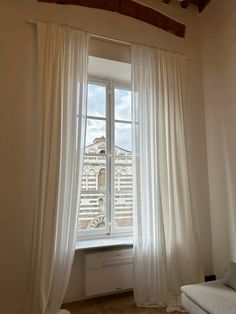 a white couch sitting next to a window in a living room