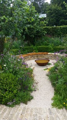 a stone bench in the middle of a garden