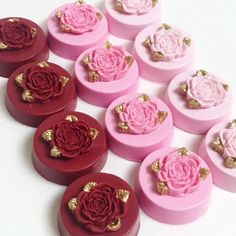 twelve pink and red roses are in the shape of small round boxes with gold trimmings