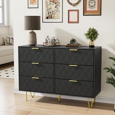 a black and gold dresser in a living room with pictures on the wall above it