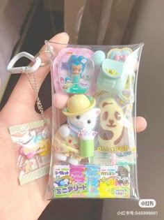 a person holding a small keychain with various items in it's package