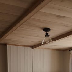 a light that is hanging from the ceiling in a room with wood paneled walls