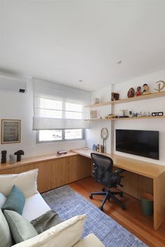 a living room filled with furniture and a flat screen tv on top of a wooden shelf