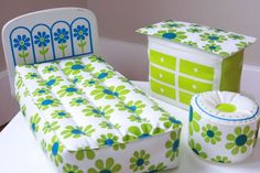 a green and white bed sitting on top of a table next to a box filled with tissues