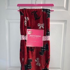 a red towel hanging on a door with a pink hanger attached to it's side