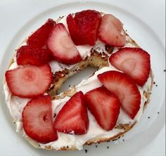 a white plate topped with a cake covered in strawberries