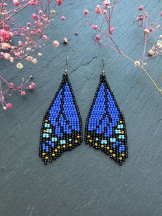 a pair of blue and yellow beaded earrings