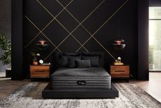 the mattress is in front of a black wall with gold geometric designs and red lines