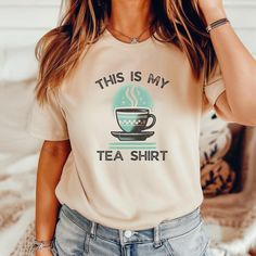 Show off your love for tea and clever wordplay with this stylish "This Is My Tea Shirt" tee! Featuring a charming retro-style illustration of a steaming cup of tea, this shirt combines vintage aesthetics with a fun food pun that's perfect for tea lovers. The muted tones and grainy textures give it a nostalgic feel, while the witty design will bring a smile to anyone who reads it. Made from soft, breathable fabric, this shirt is as comfortable as it is cute--ideal for casual wear, cozy days in, o Boosted Tea Shirts, Tea Cup Design, Food Pun, My Tea, Steaming Cup, Tea Shirt, Vintage Aesthetics, Tea Lovers Gift, Hipster Shirts