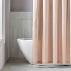 a bath tub sitting next to a white toilet under a shower curtain in a bathroom