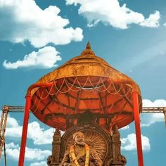 an elaborately decorated gazebo in front of a blue sky with clouds