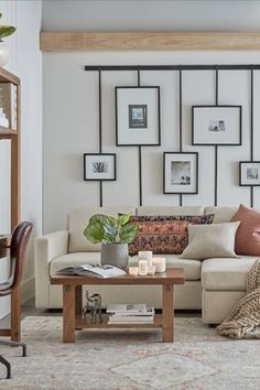 a living room filled with furniture and pictures on the wall above it's coffee table