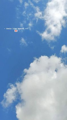 an airplane flying in the blue sky with white clouds