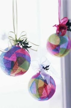 three colorful ornaments hanging from a window sill