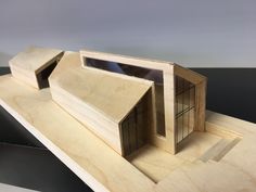 a wooden model of a house sitting on top of a table