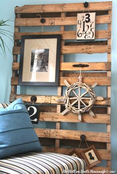 a bed made out of wooden pallets with pictures on the wall above it and a blue pillow