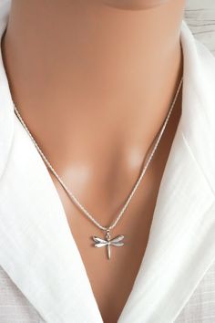 This simple and elegant dragonfly necklace is made of 925 sterling silver with a clear cubic zirconia rhinestone on the wing. It makes a lovely everyday necklace for those who love dragonflies. This necklace includes: - Dragonfly pendant: (18 x 18 mm | approx 3/4 in x 3/4 inch, including the bail) - anchor, snake, rope or curb link chain (16 to 30 inches) ADD INITIAL CHARMS: https://etsy.me/3gMPv4r ADD BIRTHSTONE CHARMS: https://etsy.me/3gGTLT4 ADD BIRTHSTONE BEAD CHARMS: https://etsy.me/3gGltzv Elegant Silver Dragonfly Jewelry, Dainty Silver Dragonfly Jewelry, Elegant Sterling Silver Dragonfly Necklace, Dainty Sterling Silver Dragonfly Jewelry, Elegant Sterling Silver Dragonfly Jewelry, Silver Dragonfly Jewelry, Dragonfly Jewelry Necklace, Sterling Silver Dragonfly Necklace, Dragonfly Gifts