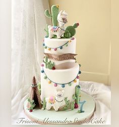 a three tiered cake decorated with animals and cactuses