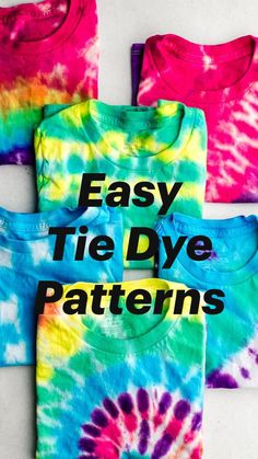 four different colors of tie - dyed t - shirts on a white surface with one blue and the other pink