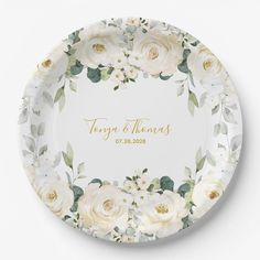 a personalized plate with white roses and greenery on the front, in gold lettering