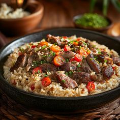 a close up of a plate of rice with meat and vegetables on it, next to other dishes