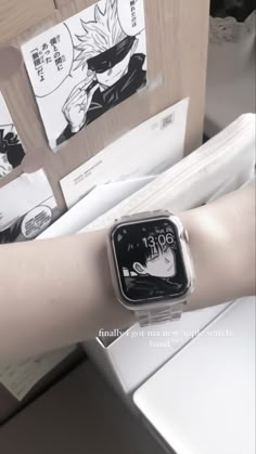 an apple watch on someone's arm with anime pictures behind it