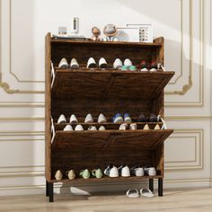 a wooden shoe rack filled with lots of pairs of shoes on top of a hard wood floor