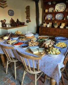 a table filled with lots of food sitting on top of a kitchen floor next to a wooden cabinet