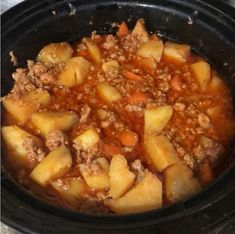 a crock pot filled with meat and potatoes