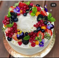 a cake decorated with fresh fruit and flowers