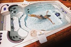 a woman is swimming in an indoor hot tub