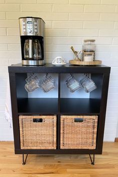 a black cabinet with wicker baskets on it and a coffee maker in the background