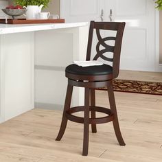 a wooden bar stool sitting on top of a hard wood floor next to a counter